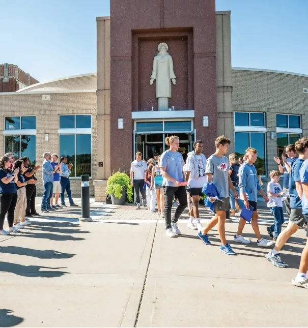 Students exiting chapel on a sunny day.